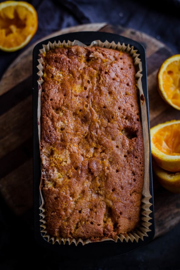 Cake with holes all over and oranges to side