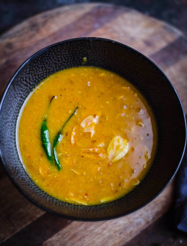 Red Lentil Dahl in a bowl with garlic and green chillies on top