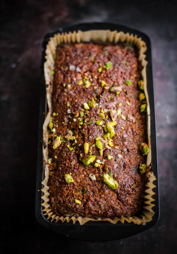 Pistachio Loaf Cake in a loaf tin with pistachios on top