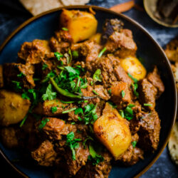 Lamb and Potatoes in a bowl with roti at the side
