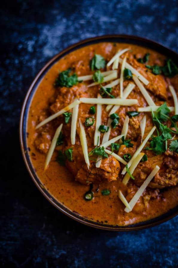 Patiala Chicken in a blue bowl topped with slivered ginger and coriander