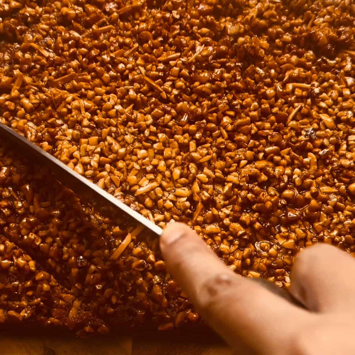 Baklava Cake with Honey Nut Topping & Citrus Cardamom Syrup Baklava being cut into diamond shapes