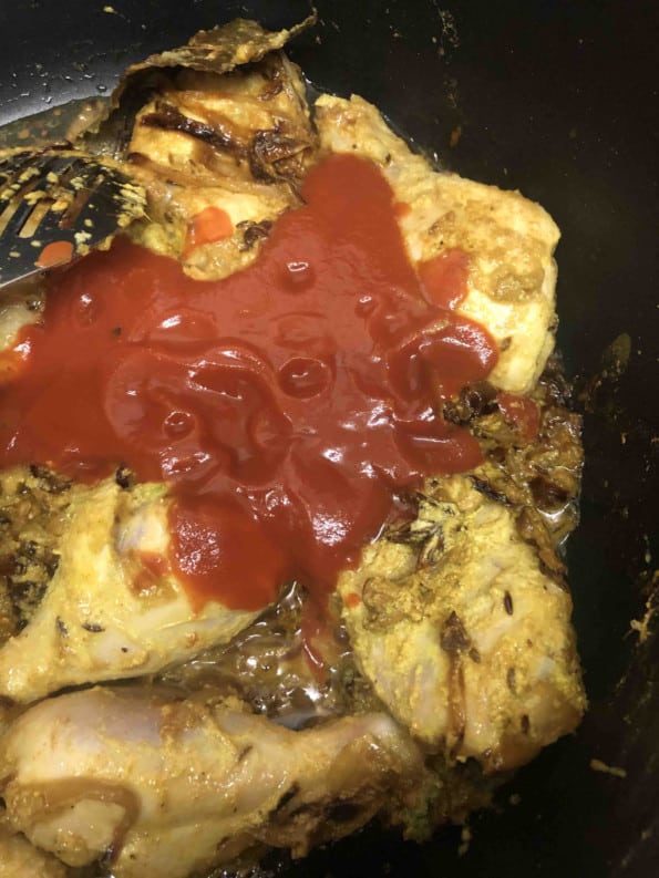 Tomato added to chicken in pot
