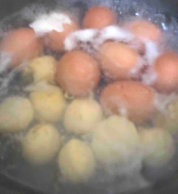 Eggs and Potatoes boiling in a pot