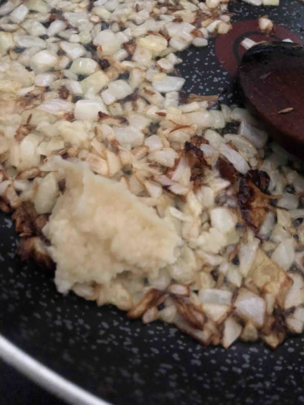 Onions being fried in a pan
