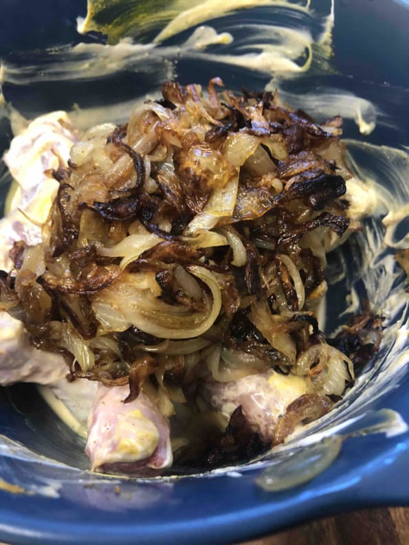Fried onions added to Chicken marinade in bowl