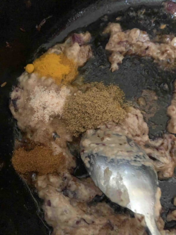 Ground Spices being stirred in pot with a metal spoon