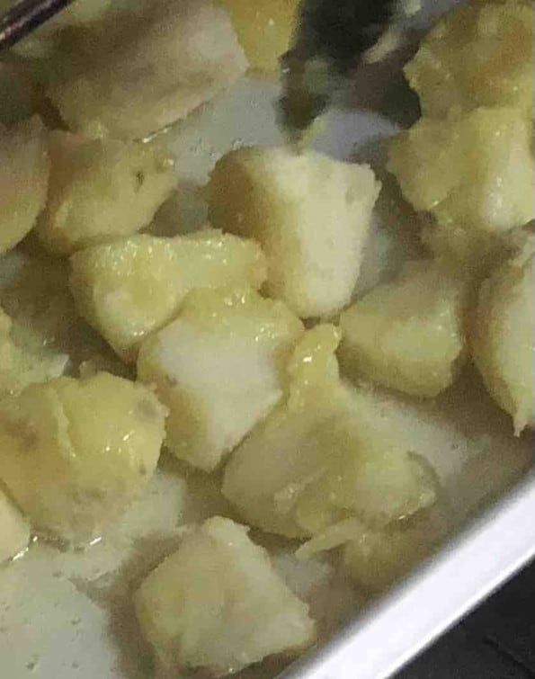 Potatoes being added to oil in hot pan