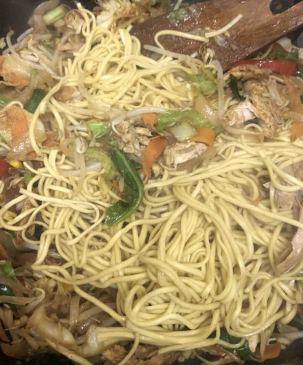 Noodles being stirred in wok
