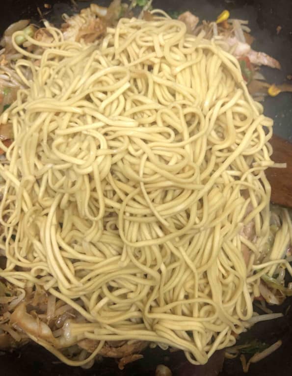 Noodles added to wok