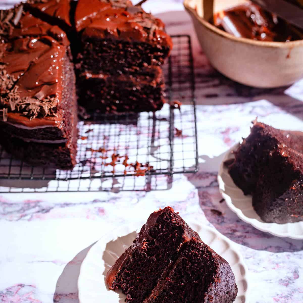 Chocolate cake with slices and ganache on table