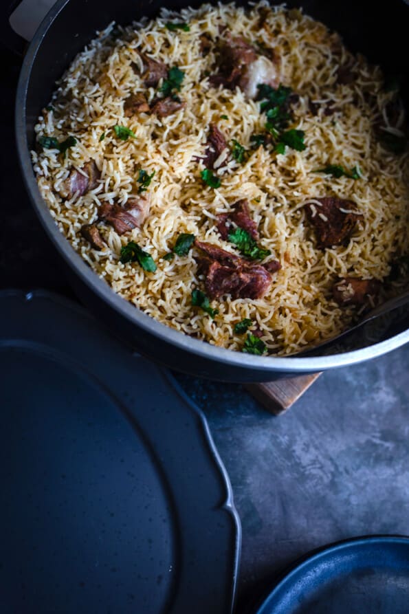 Mutton Pulao in pot with dishes to side