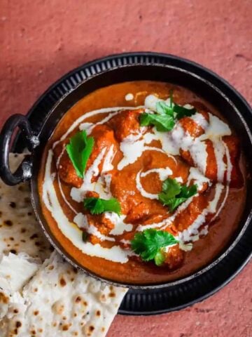 Butter Chicken in a dish with naan to side