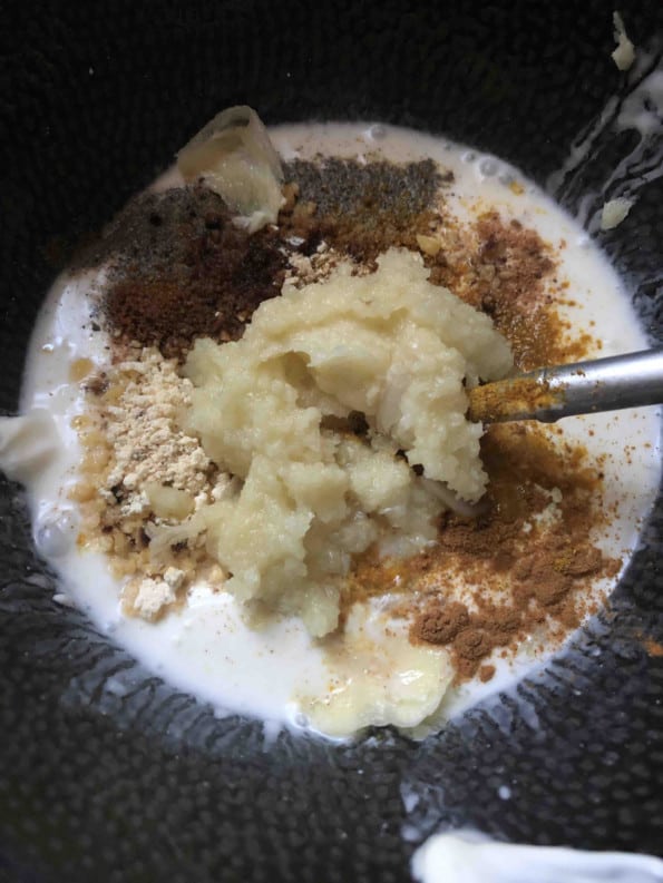 Garlic added to bowl with yoghurt and spices