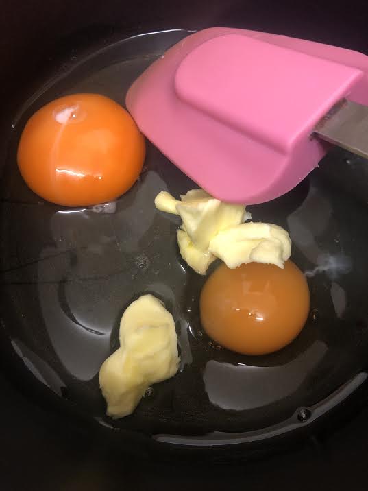 Spatula in pot with eggs and butter