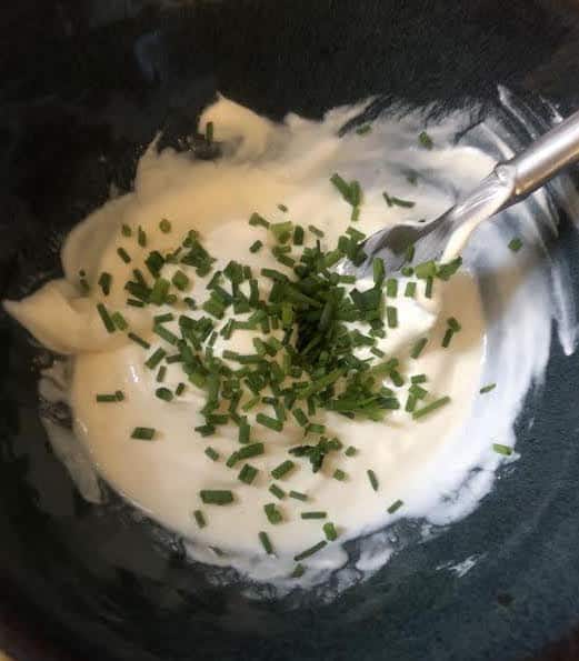 Creme fraiche and chives in a bowl with a fork