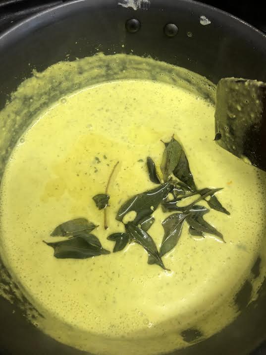 Curry leaves added to yoghurt soup