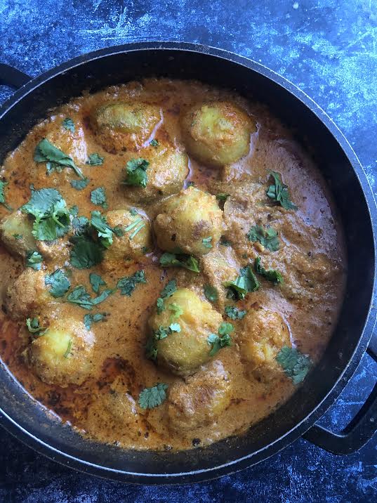 Potatoes added to pot with coriander on top