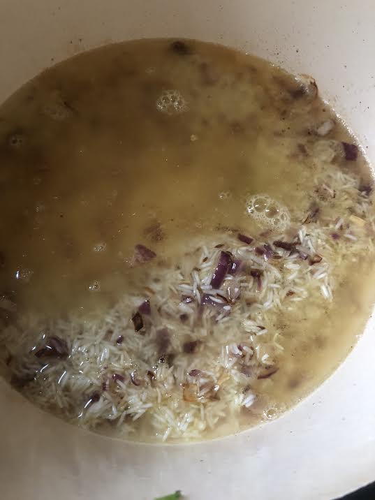 Rice, stock and onions added to pot