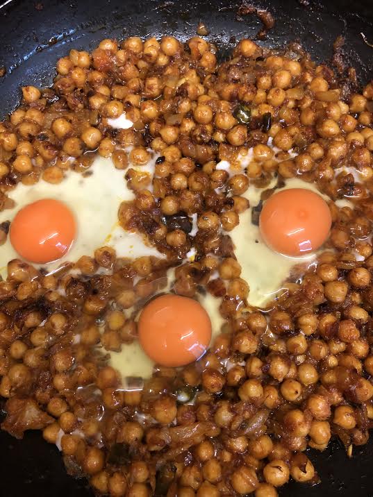 3 Eggs cracked in chickpeas in pan