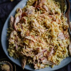 Chicken Orzo on a blue platter with flowers scattered around sides
