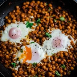 Chickpeas in a pan with 3 eggs on top
