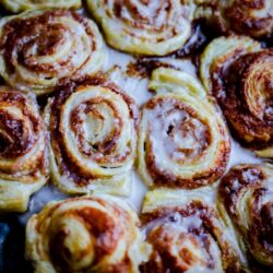 Puff Pastry Cinnamon Rolls on a tray, topped with icing