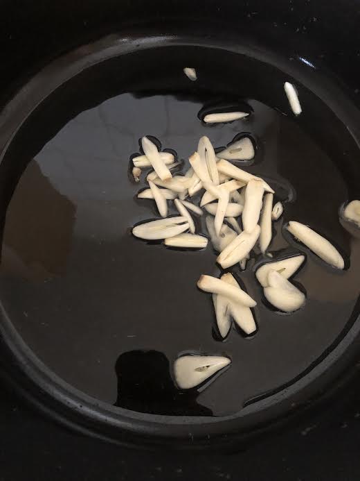 Garlic added to oil in pot