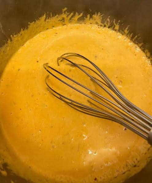 SAuce being whisked in pot