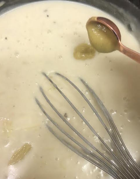 Mustard being added to cheese sauce