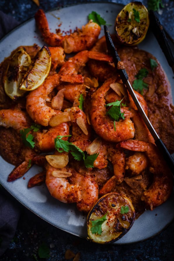 Tandoori Prawns in platter with lemons and coriander scattered on top