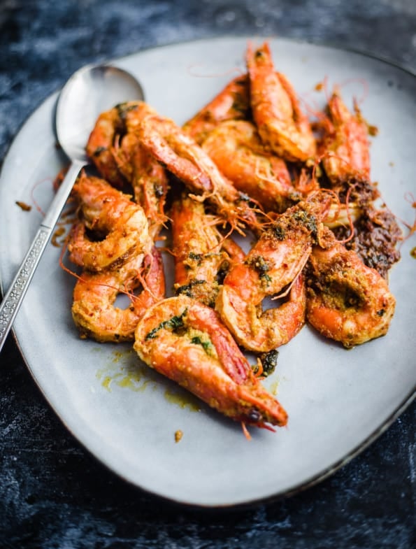 Tandoori prawns in a blue platter with large spoon to side