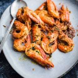 Tandoori prawns in a blue platter with large spoon to side