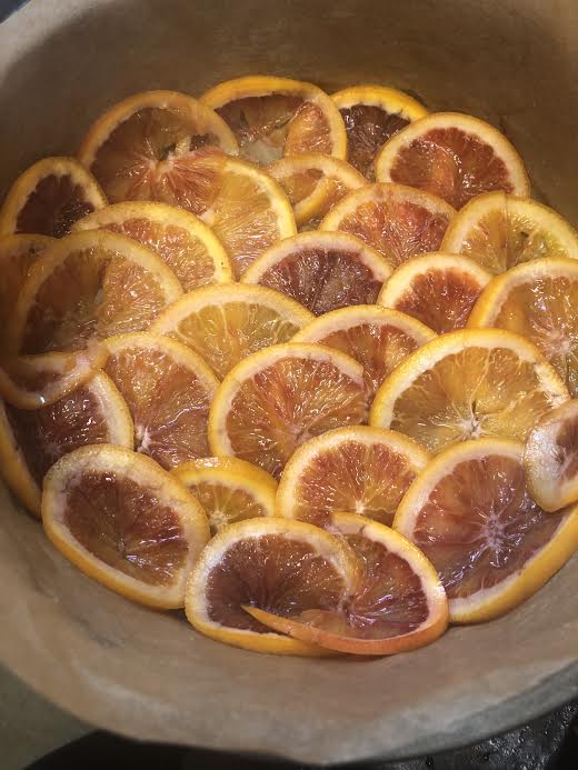 Blood oranges laid out at the bottom of a lined cake tin