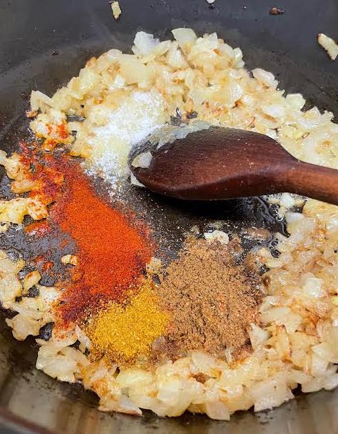 Spices added to onions in pot