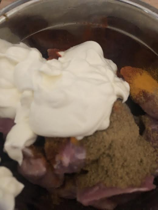 Yoghurt added to meat in bowl for marinade