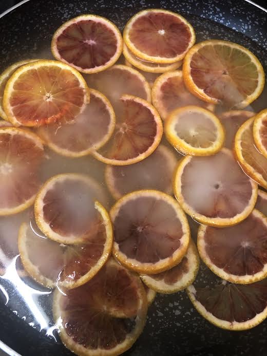Blood oranges in syrup in pan