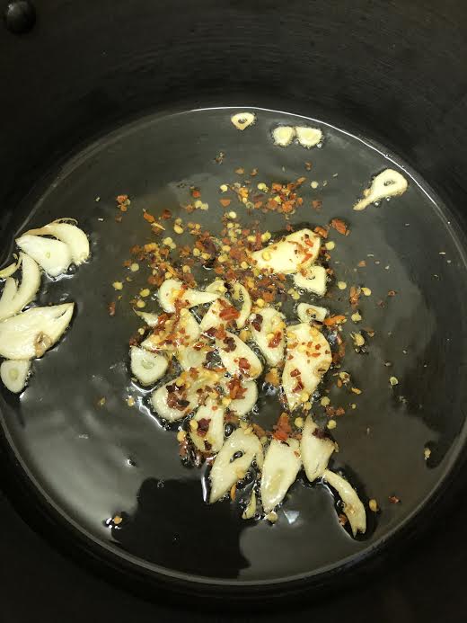 Garlic and red pepper flakes in oil in pot