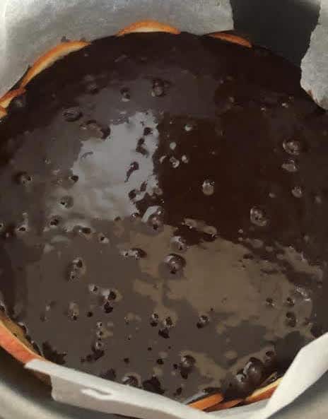 Chocolate mixture poured over oranges in cake tin