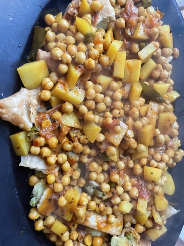 Chickpeas added on top of Samosas in dish