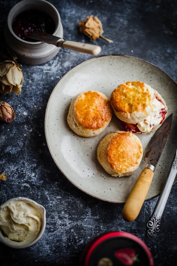 3 scones in plate with clotted cream and jam