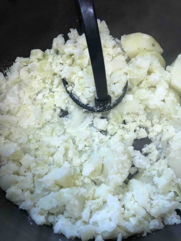Potatoes being mashed in a pot