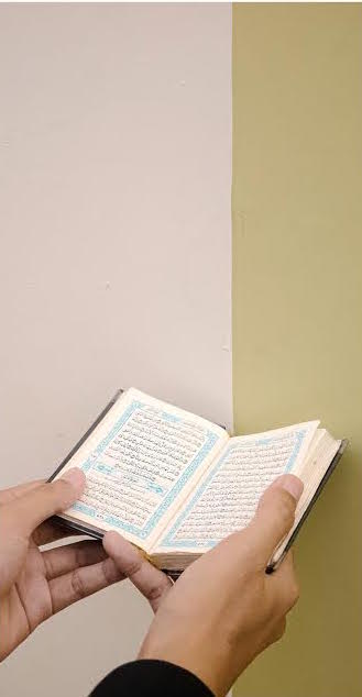 Hands holding open Quran