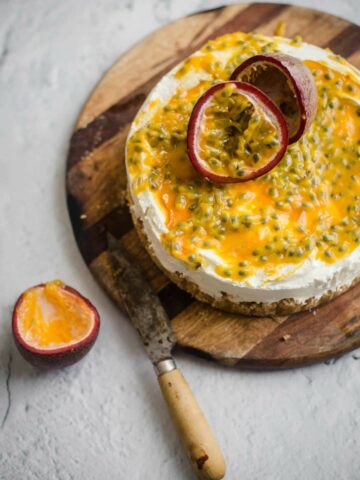 Passionfruit Cheesecake on a board with a knife to the side