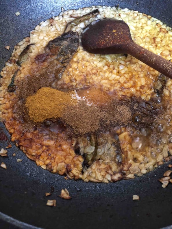 Spices added to onions in wok