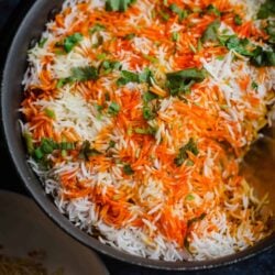 Prawn Biryani in a pot with coriander and coloured rice on top