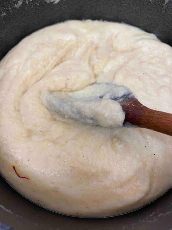 Creamy Soji being stirred with wooden spoon in pot