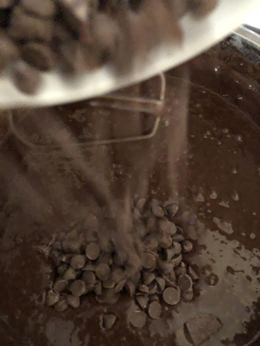 Chocolate chips being stirred into batter