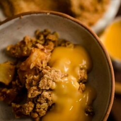Apple Crumble in a bowl with custard