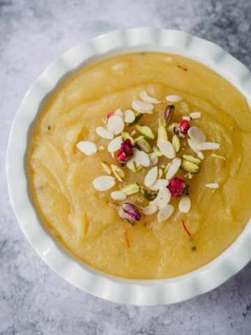 Soji Halwa in a bowl topped with flaked almonds
